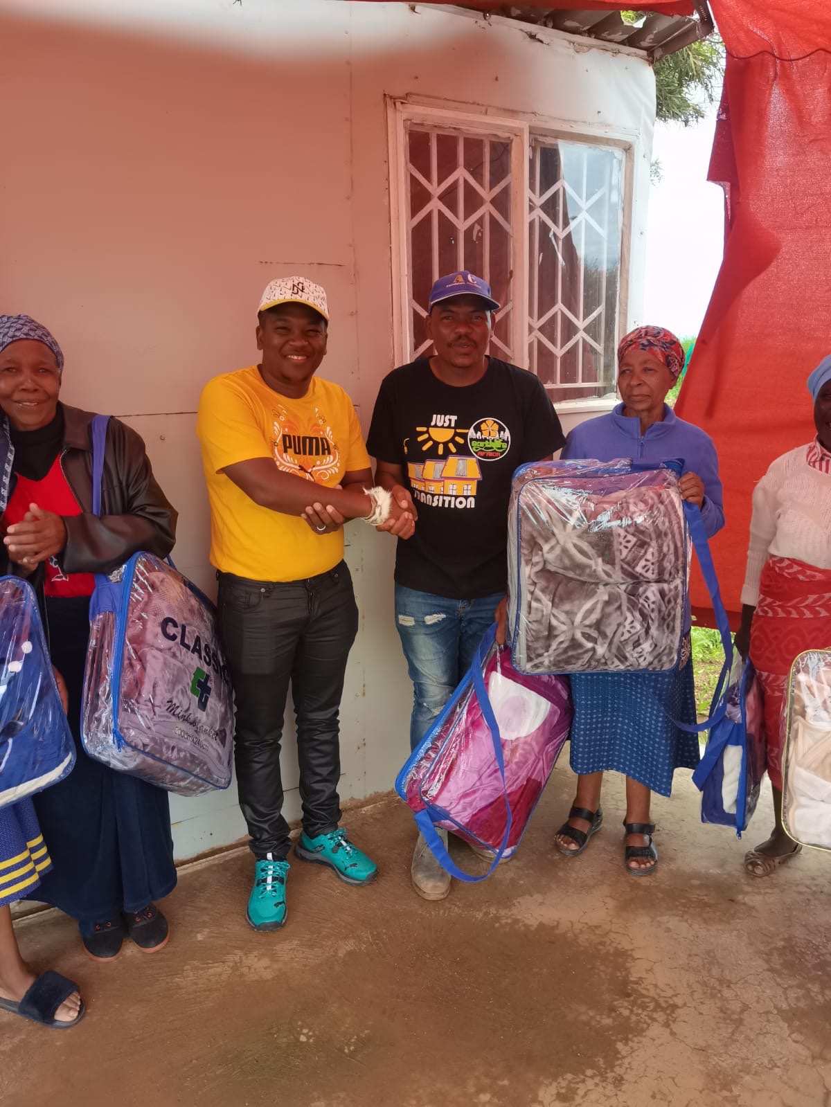 Isicholo team handing over blankets to community elders